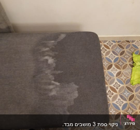 ספה אפורה עם כתם רטוב ותהליך ניקוי